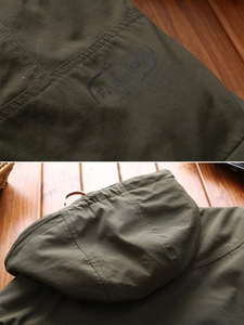 Detail of dark olive green outdoor jacket featuring fashion print and double stitching