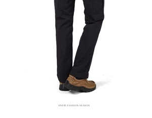 Détail du bas du pantalon de sport pour hommes avec chaussures de randonnée brunes