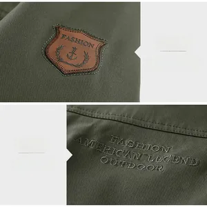 Detail of army green outdoor jacket featuring leather sleeve patch and chest embroidery