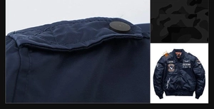 Detail view of navy bomber jacket featuring military embroidery patches and arm pocket