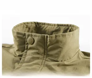 Detail of stand collar on khaki vest with engraved logo button and twill fabric