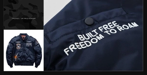 Detailed view of military patches and white 3D embroidery on navy bomber jacket