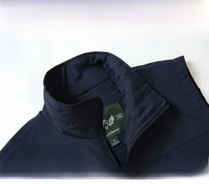 Detail of navy blue stand collar with zip-up design and green size label on vest