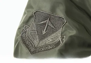 Detailed close-up of shield embroidery on green nylon MA-1 military flight jacket