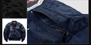 Detail of navy bomber jacket featuring military badges and zippered sleeve pocket