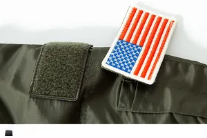 Detail of army green MA-1 flight jacket showing velcro patch area and US flag embroidery