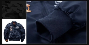 Detail view of navy blue bomber jacket showing ribbed cuffs and military-style embroidery