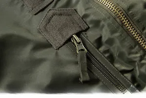 Close-up of durable metal zipper and olive green nylon fabric on MA-1 flight jacket