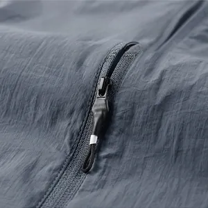 Detail des hochwertigen Reißverschlusses und des grauen wasserfesten Stoffes der Sonnenschutzjacke