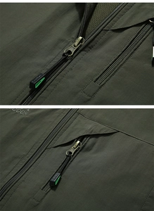 Detail of high-quality metal zippers and ripstop fabric on olive green outdoor vest