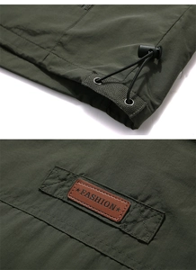 Detail of army green quick-dry vest showing drawstring hem and fashion leather patch