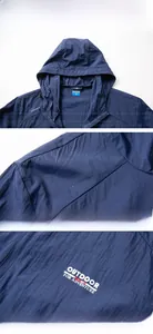Detail of navy blue hooded jacket featuring outdoor slogan print and ripstop texture