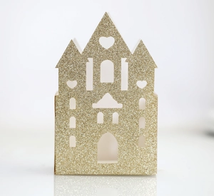 Detail of glittery gold castle favor box with laser-cut windows for wedding treats