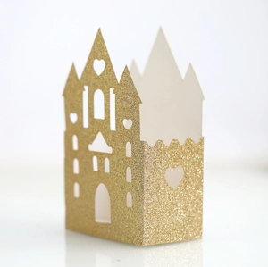 Detail of laser-cut gold glitter castle favor box with heart and window patterns
