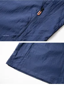 Detail of dark blue sun protection jacket with orange zipper pulls and stitched hemline