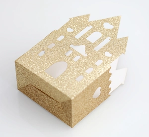 Detailed view of hollow castle wedding favor box with gold glitter finish and heart cutout
