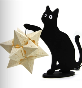 Detailed laser-cut star paper lantern held by a black cat silhouette lamp for Halloween