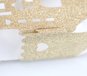 Close-up of glitter gold castle candy box with laser-cut hollow heart pattern