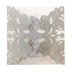 Detail of silver laser-cut hollow card with floral patterns and holiday text