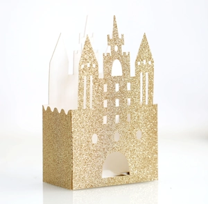 Detail of gold glitter castle candy box with intricate hollow cutouts for wedding favors