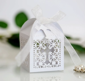 Macro detail of laser-cut white favor box with elegant cross pattern and satin ribbon