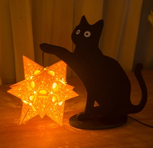 Detailed view of the black cat silhouette lamp with an intricate star-shaped glowing lantern