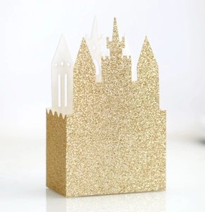 Close-up of golden glitter castle-shaped favor box for weddings with sparkling texture