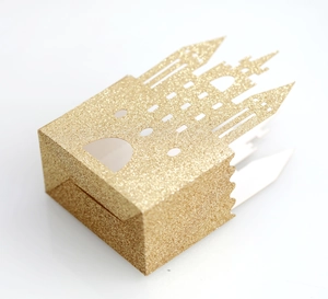 Detail of laser-cut gold glitter castle favor box for weddings and parties