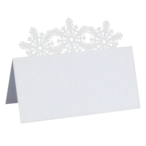 Laser-cut white snowflake place cards made of pearlescent paper for winter holiday tables
