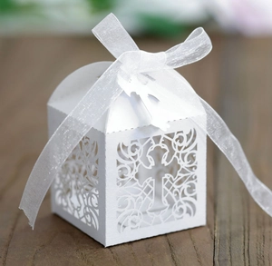 White laser cut hollow wedding favor box with cross pattern and silk ribbon tie