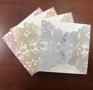 Detail showing laser-cut glitter wedding invitations with elegant European vine patterns