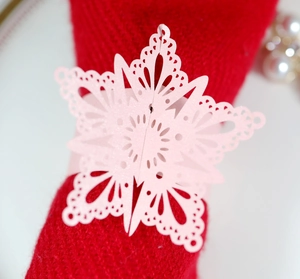 Pink laser-cut butterfly napkin ring in pearlescent paper on a red fabric background