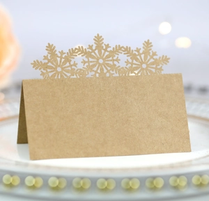 Close-up of laser-cut snowflake place card on white ceramic plate for table setting