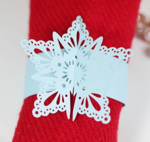 Laser-cut light blue pearl paper snowflake napkin rings for elegant holiday table decor