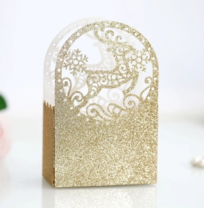 Detailed view of hollow reindeer and snowflake design on a gold glitter gift box