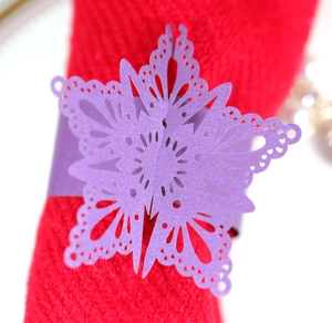 Macro detail of purple laser-cut butterfly napkin ring on red table cloth for wedding