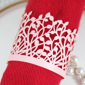 Pink laser-cut leaf pattern paper napkin ring on red napkin for wedding table decor