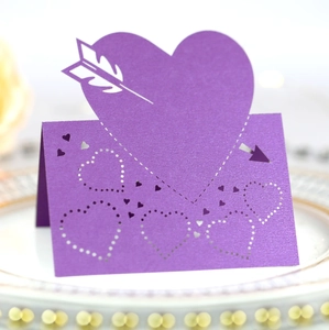 Purple laser-cut heart place cards with cupid arrow design for wedding table decor