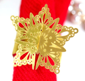 Macro shot of gold snowflake napkin ring with intricate cutout metal texture for Christmas
