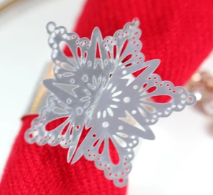Macro shot of silver metal snowflake napkin ring with intricate hollowed snowflake pattern