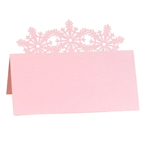 Pink laser-cut snowflake place cards with pearl finish for Christmas wedding tables
