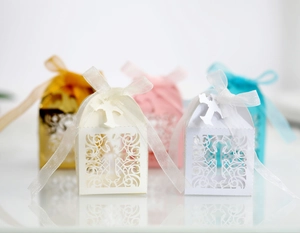 Detail of laser-cut candy boxes with cross patterns and organza ribbon bows
