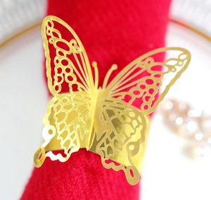 Detailed close-up of golden hollow butterfly napkin ring with intricate cut-out patterns
