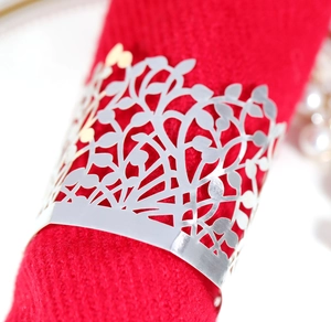 Macro shot of silver hollowed tree leaf napkin ring on a elegant red cloth napkin