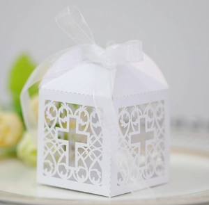Détail de la boîte à bonbons blanche découpée au laser avec motif croix et ruban blanc