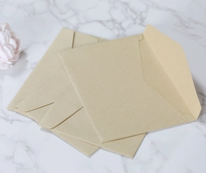 Detailed view of premium kraft paper envelopes on a marble surface with floral accents