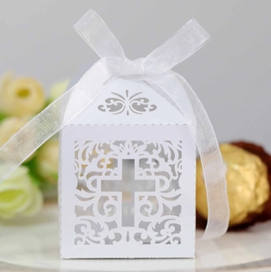 Laser-cut white wedding favor box with cross design and elegant organza ribbon