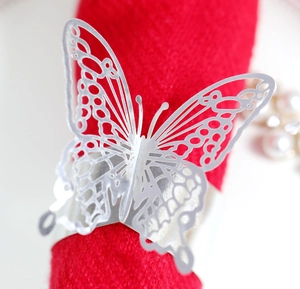 Detailed macro view of laser-cut butterfly napkin ring with shiny silver metal texture