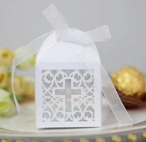 Détail boîte cadeau blanche découpée au laser avec croix évidée et ruban d'organza