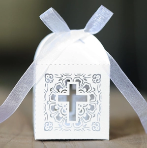 Detail of laser-cut cross floral pattern on white pearlescent paper wedding candy box
